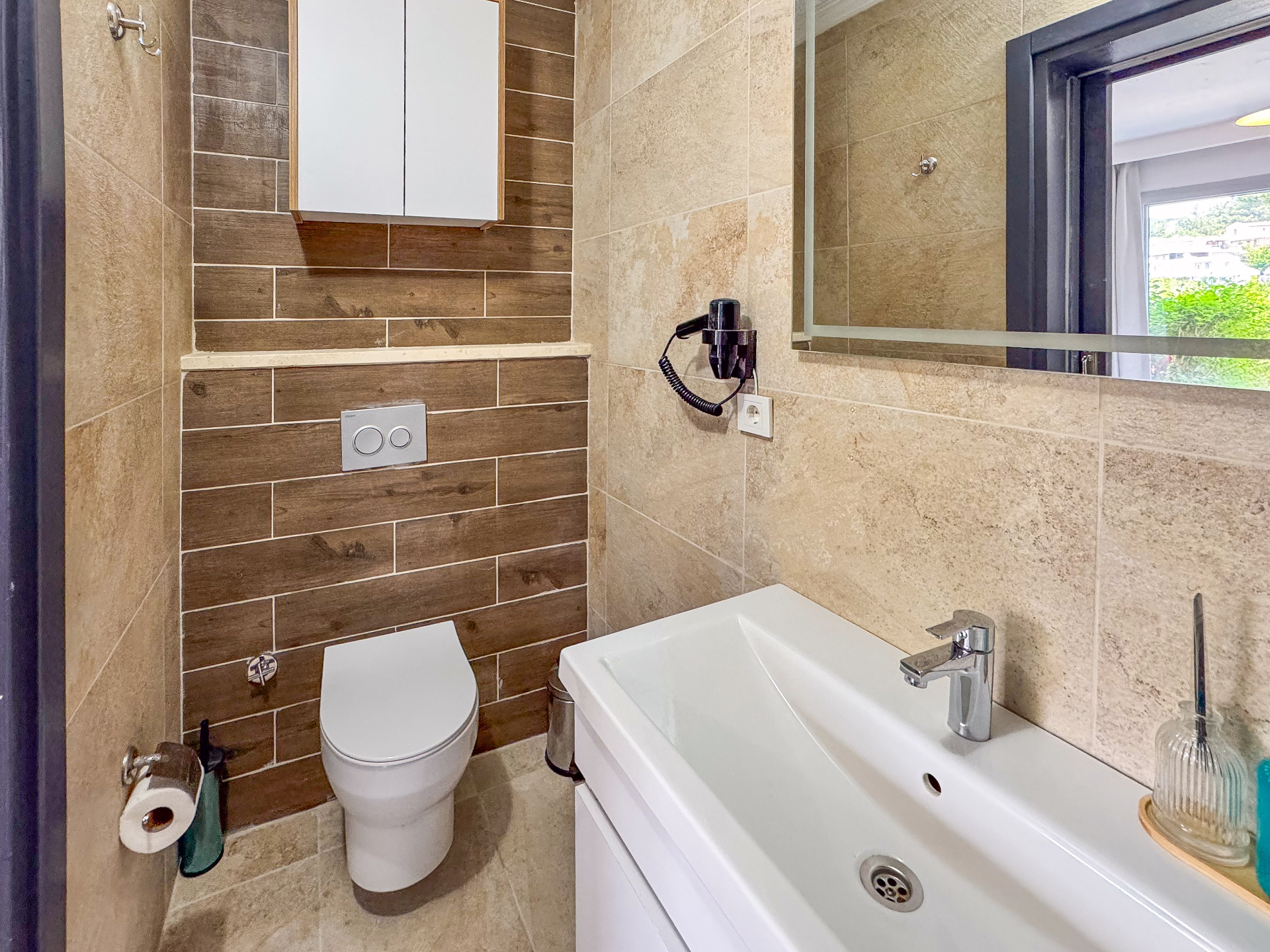 Bathroom with wood-effect feature tiles, wall-hung WC and large white vanity