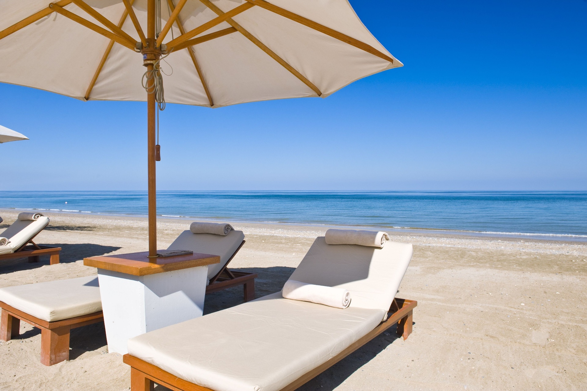 Sun loungers and umbrella on the soft sand of Long Beach Kuşadası