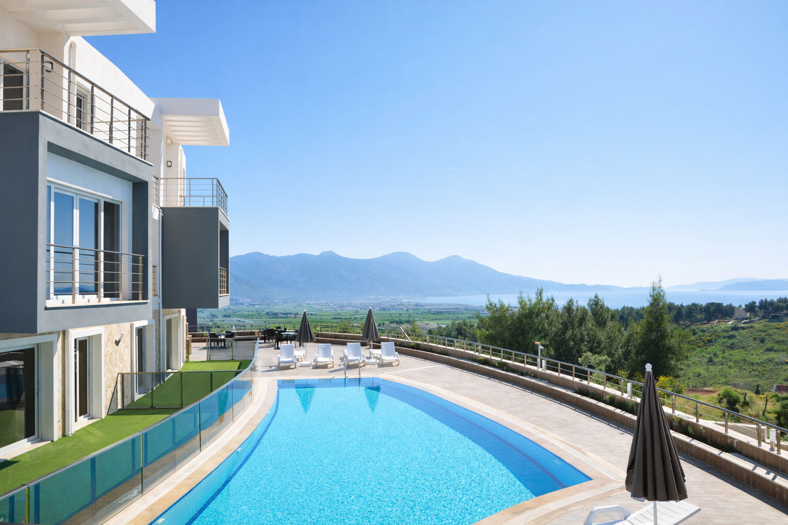 Outdoor pool with Aegean view, framed by pines