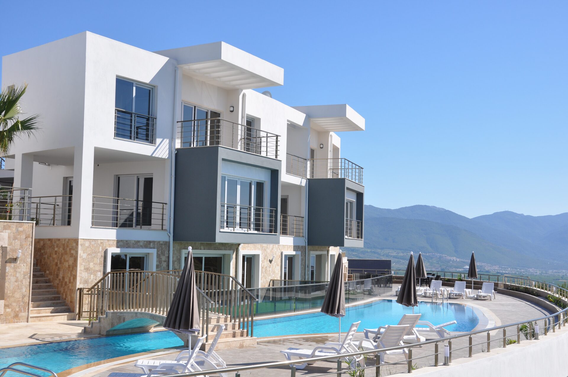 Front elevation of the Lavender Residence buildings above the curved swimming pool